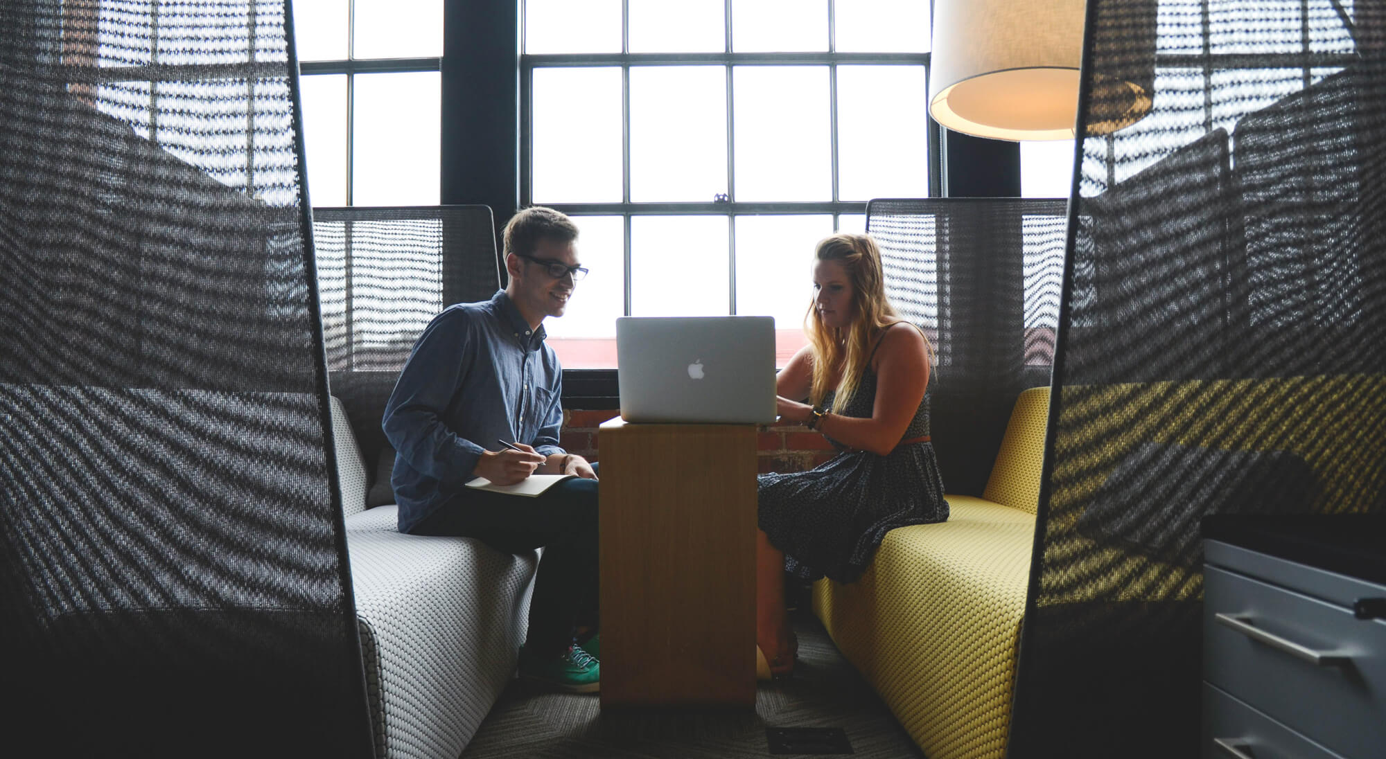 a man and woman looking at a laptop